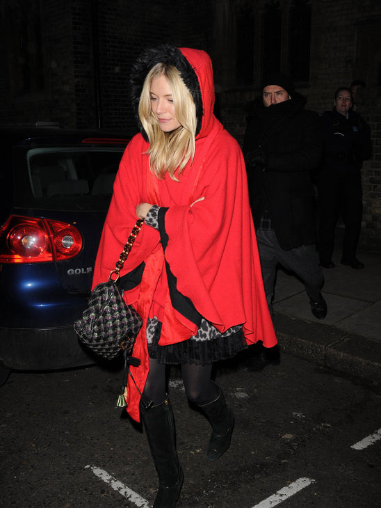 Sienna Miller gets into the holiday spirit with this bright red cape with the hoodie. Very sexy Santa!